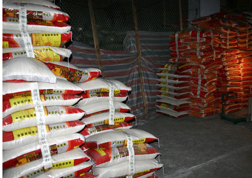 在另一间仓库,地上倒着一大堆大米,旁边还有与该米不种品质的大米