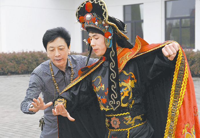 学员海峰(右一)的执着感动了川剧变脸大师彭登怀,并为他设计了"舞之